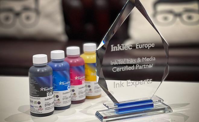 An award from InkTec Europe to inkexperts on a table next to four bottles of printer ink